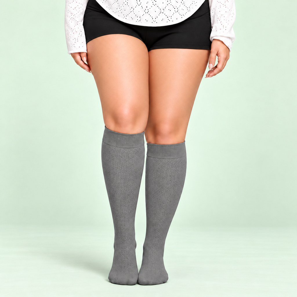 Gray bamboo compression socks, standing front view on a pale sage background