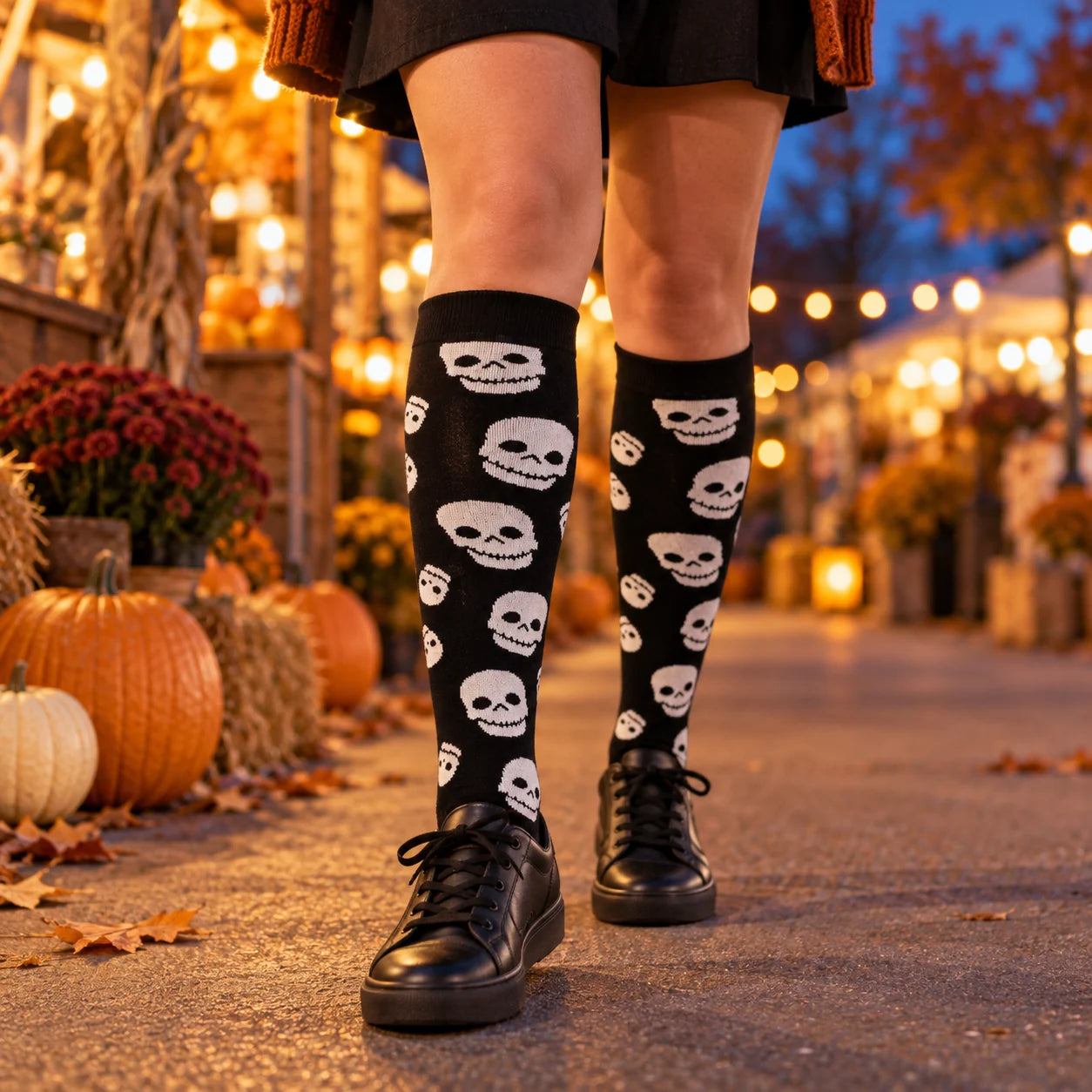 Black grinning-skull knee-high socks worn at an autumn evening market