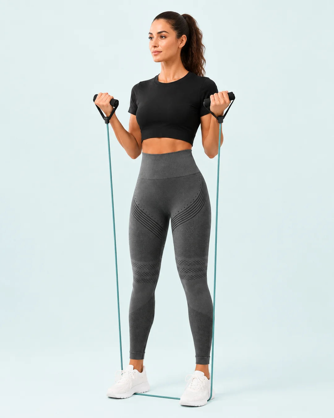 A woman wearing SKIN ELITE CO. leggings during a light resistance-band workout