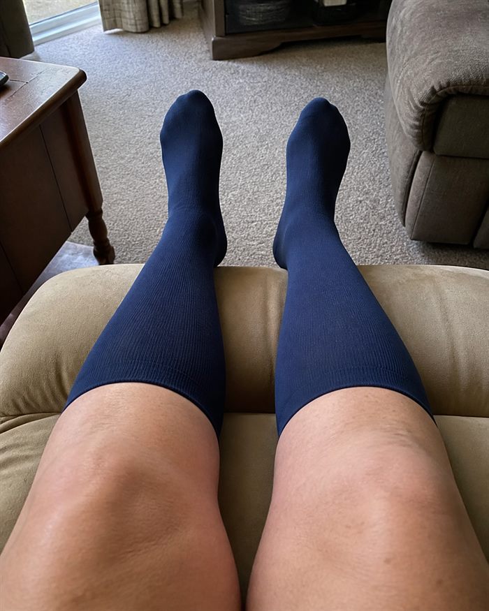 First-person view of navy knee-high socks during an afternoon rest at home