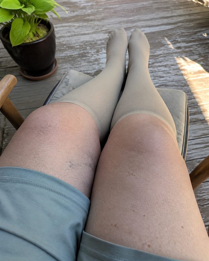 First-person view of beige knee-high socks during a rest outdoors